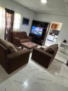 un soggiorno con divani e TV a schermo piatto di Alquiler miramar a Miramar