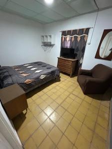 una camera con letto, sedia e TV di Alquiler miramar a Miramar