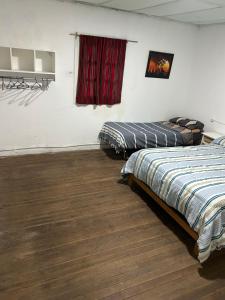 2 letti in una camera con finestra rossa di Alquiler miramar a Miramar