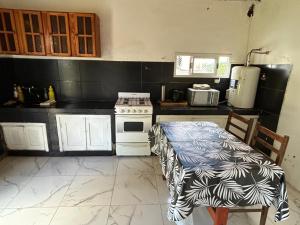 una cucina con piano cottura e tavolo di Alquiler miramar a Miramar