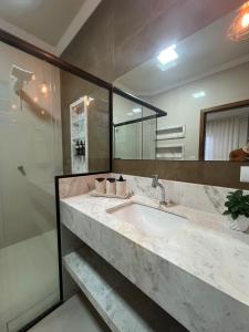 ein Badezimmer mit Waschbecken und Dusche in der Unterkunft Flow Pousada in Maringá + 20 Fotos