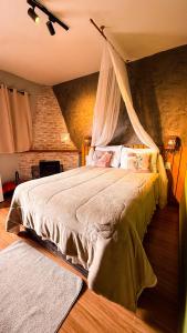 a bedroom with a bed with a mosquito net at Pousada Bosque in Monte Verde +53 photos