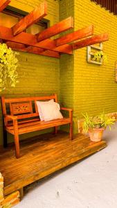 a bench sitting on a porch with a yellow wall at Pousada Bosque in Monte Verde