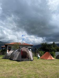 eine Gruppe Zelte im Gras vor einem Haus in der Unterkunft Zona de Camping El mirador in Villa de Leyva + 5 Fotos