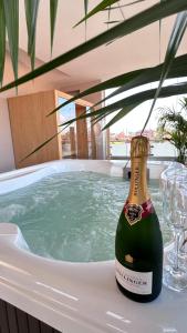 a bottle of champagne sitting in a bath tub at Mediterranea Apartments Aurora in Assemini