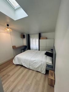 a bedroom with a white bed and a wooden floor at Maison et chambre privée - Bordeaux in Bordeaux