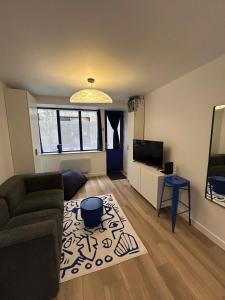 a living room with a couch and a tv at Maison et chambre privée - Bordeaux in Bordeaux