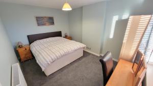 a small bedroom with a bed and a desk at Stornoway Stays in Stornoway