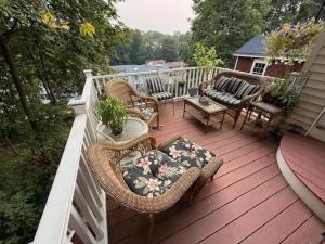 a porch with wicker chairs and chairs on a deck at Gallows Hill Guest House in Salem