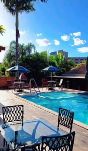 een zwembad met stoelen en parasols ernaast bij Pousada Gravatá in Gravatal