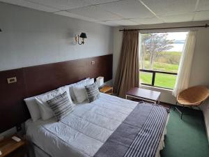 a bedroom with a bed and a large window at Hotel HD Natales in Puerto Natales