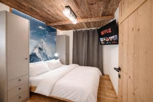 a bedroom with a large white bed with a mountain mural at OLDWOOD CHALET - AlpenLuxus Collection in Fügen
