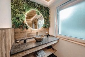 a bathroom with a sink and a mirror at OLDWOOD CHALET - AlpenLuxus Collection in Fügen