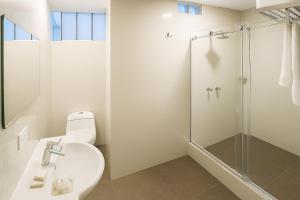 a bathroom with a toilet and a glass shower at City Tower Hotel in Lima