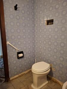 een badkamer met een toilet en blauwe betegelde muren bij Lo de Olga in Trelew +12 foto's