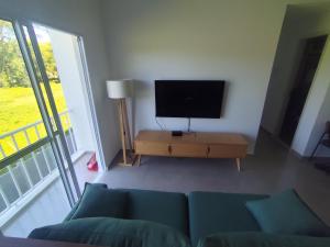 a living room with a couch and a flat screen tv at Apartamento 2 Quartos com Ar Condicionado in Paraty