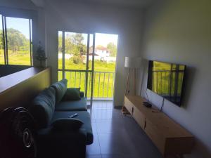 a living room with a couch and a flat screen tv at Apartamento 2 Quartos com Ar Condicionado in Paraty