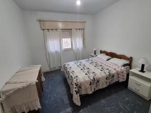 een witte slaapkamer met een bed en een raam bij Lo de Olga in Trelew