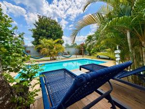 a blue bench sitting on a deck next to a swimming pool at L´Grace Ferradura in Búzios