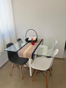 ein Glastisch mit Stühlen und einem Korb darauf in der Unterkunft Casa de Praia Vila do Peró in Cabo Frio