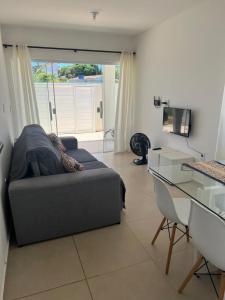 ein Wohnzimmer mit einer Couch und einem Glastisch in der Unterkunft Casa de Praia Vila do Peró in Cabo Frio