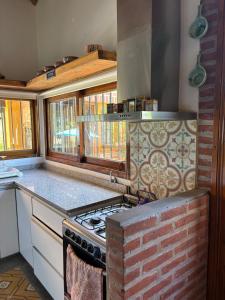 - une cuisine avec une cuisinière et un mur en briques dans l'établissement Casa Quinta La Plata, à La Plata