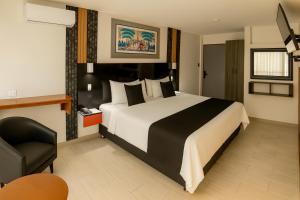 een hotelkamer met een groot bed en een stoel bij City Tower Hotel in Lima