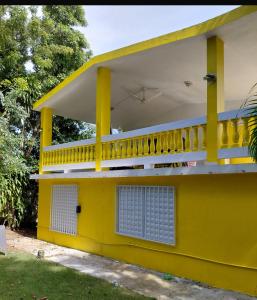 ein gelbes Gebäude mit einem Balkon darauf in der Unterkunft Casa Peace Haven Beach House Aguada in Aguada