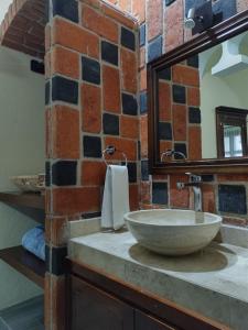 een badkamer met een stenen wastafel en een spiegel bij Mirador Johya Hotel in Bernal