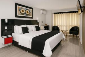 a hotel room with a large bed and chairs at City Tower Hotel in Lima +42 photos