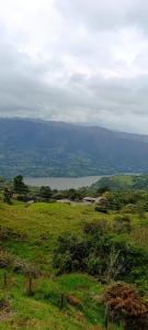 a grassy field with a view of a body of water at Supernova Glamping in Macanal