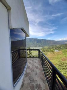 a balcony of a house with a view of the mountains at Supernova Glamping in Macanal