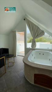 een badkuip in een kamer met een groot raam bij Mirador Johya Hotel in Bernal
