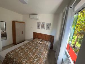 een kleine slaapkamer met een bed en een raam bij Condomínio Ecoville das Mangueiras Região de Praia de Guarajuba in Camassari +15 foto's