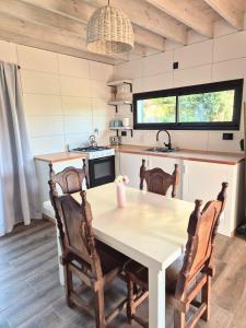a kitchen with a table and chairs in a kitchen at Mardel Chapla in Colonia Chapadmalal +14 photos