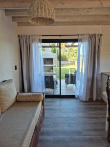 a living room with a couch and a sliding glass door at Mardel Chapla in Colonia Chapadmalal
