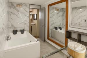 a bathroom with a white tub and a sink at City Tower Hotel in Lima
