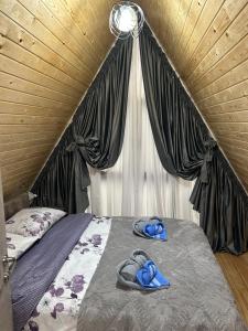 a bed with blue slippers on top of it at Cottage Godzia in Sadgeri