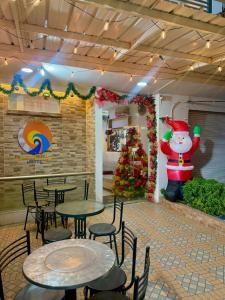 a restaurant with tables and chairs and a christmas tree at ANAJIRAWAA HOTEL in Ríohacha