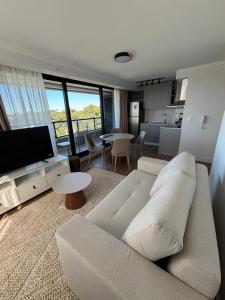 a living room with a white couch and a kitchen at Sea Garden Tower 2 in Punta del Este
