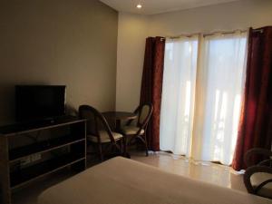 a living room with a television and a table with chairs at Boracay White Coral Hotel in Boracay