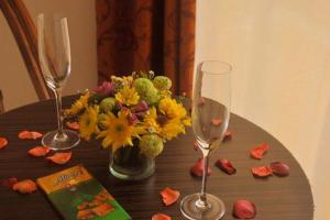 a table with two wine glasses and a vase of flowers at Boracay White Coral Hotel in Boracay