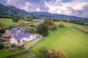 an aerial view of a house in a green field at Llwyn-Y-Coed-Isaf in Llanbedr-y-cennin