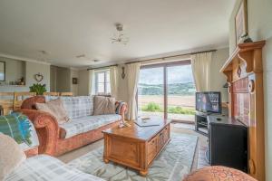 a living room with a couch and a tv at Llwyn-Y-Coed-Isaf in Llanbedr-y-cennin