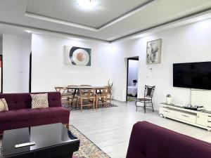 een woonkamer met een bank, een tv en een tafel bij River Side in Abidjan