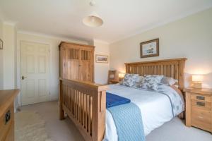 a bedroom with a wooden bed and a wooden dresser at Llwyn-Y-Coed-Isaf in Llanbedr-y-cennin