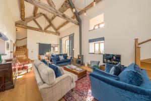 a living room with blue couches and a tv at The-Longbarn in Ruthin