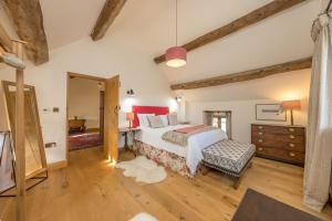 a bedroom with a bed and a dresser in a room at The-Longbarn in Ruthin