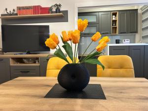 a vase with yellow flowers sitting on a table at Hram View Apartment, Valjevo Center in Valjevo