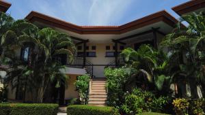 a house with palm trees in front of it at Corteza 2BD Gated AC Quiet Terrace Pools in Jacó